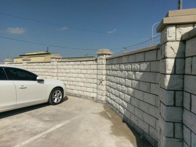 me09-1 →采用【石纹砖】象牙白,搭配白色帽盖,堆砌而成之围墙.